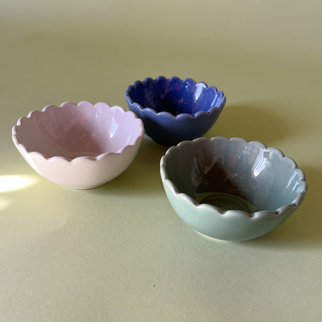 three scalloped bowls in white, blue and green