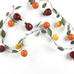 a chinoiserie christmas garland decorated with tole metal pomegrantes, oranges and lemons and green leaves. 