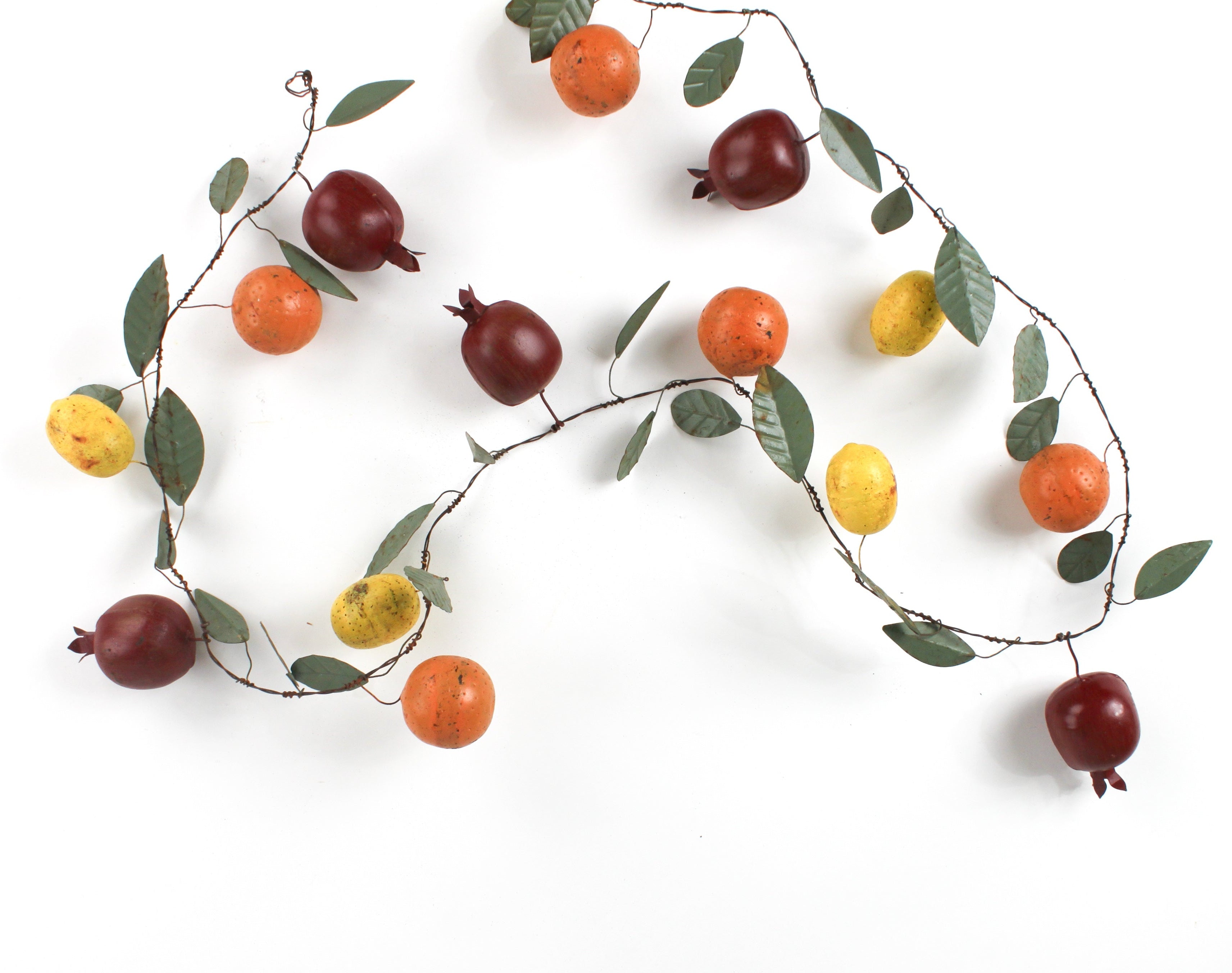 a chinoiserie christmas garland decorated with tole metal pomegrantes, oranges and lemons and green leaves. 