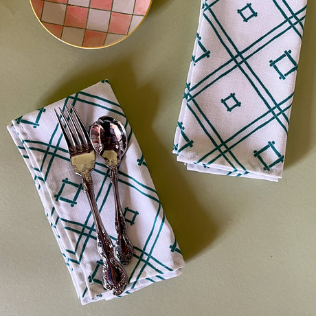 white and green dinner napkins in Island House Small trellis print madcap cottage fabric against a light green background