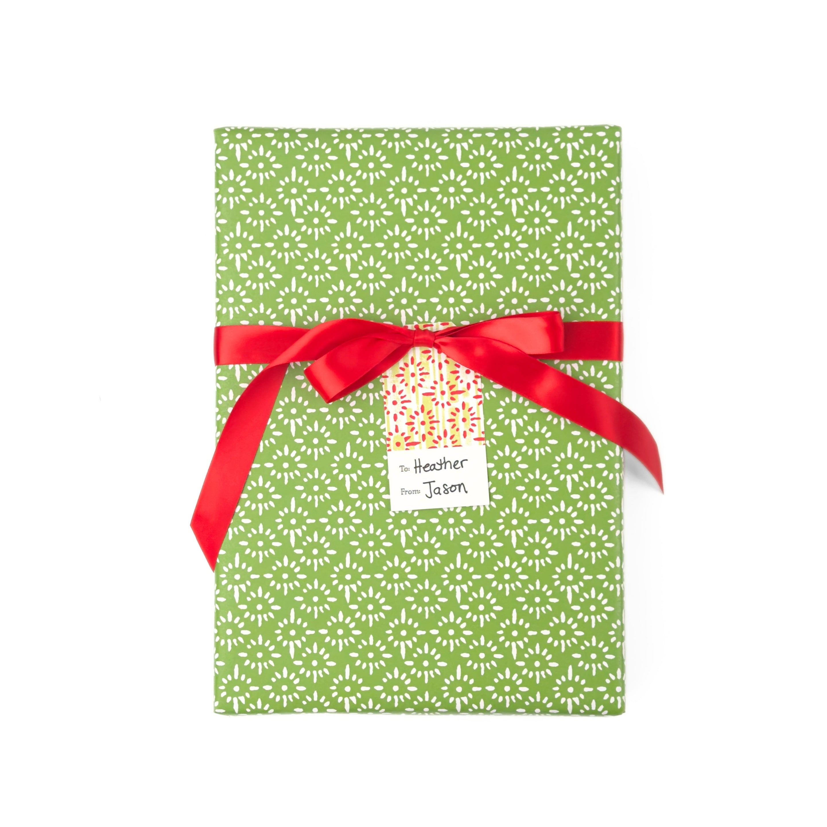 Elegant gift wrap featuring delicate white floral patterns on a vibrant green background for beautiful presents.