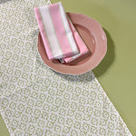 Detail view of white Toujours Provence cloth table runner with a celery green block print motif.