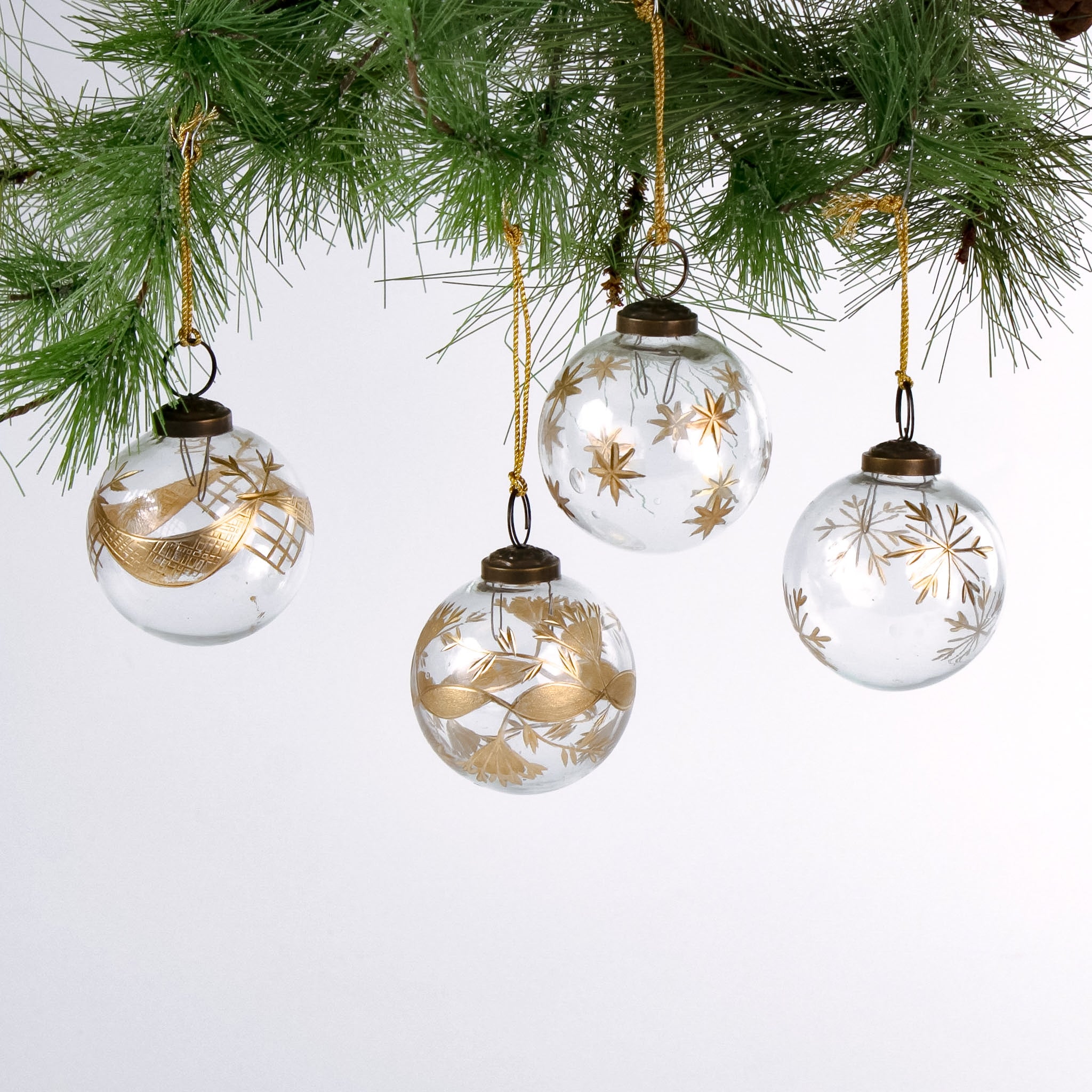 Set of 4 clear glass Christmas ornaments with elegant gold leaf and star designs, featuring gold hanging cords — perfect for adding a touch of luxury to holiday décor.