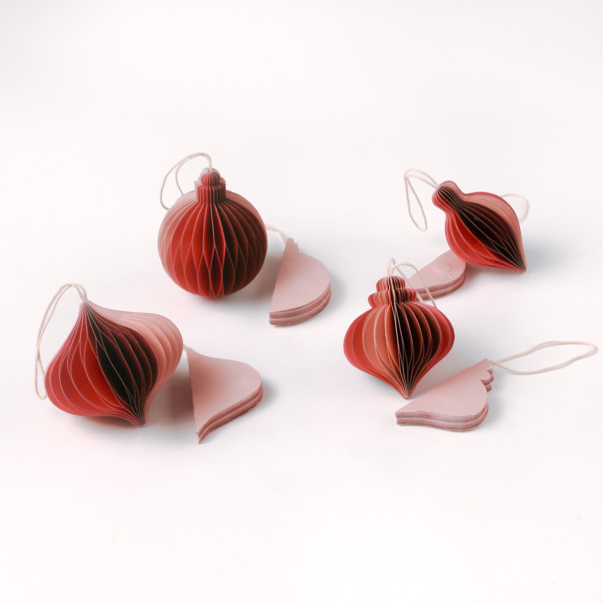 Set of folded paper pink Christmas ornaments in assorted bulb shapes with hanging string