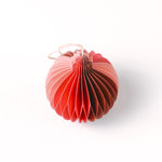 Close-up of pink folded paper Christmas ornaments in assorted bulb and teardrop shapes with hanging strings