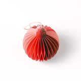 Close-up of pink folded paper Christmas ornaments in assorted bulb and teardrop shapes with hanging strings