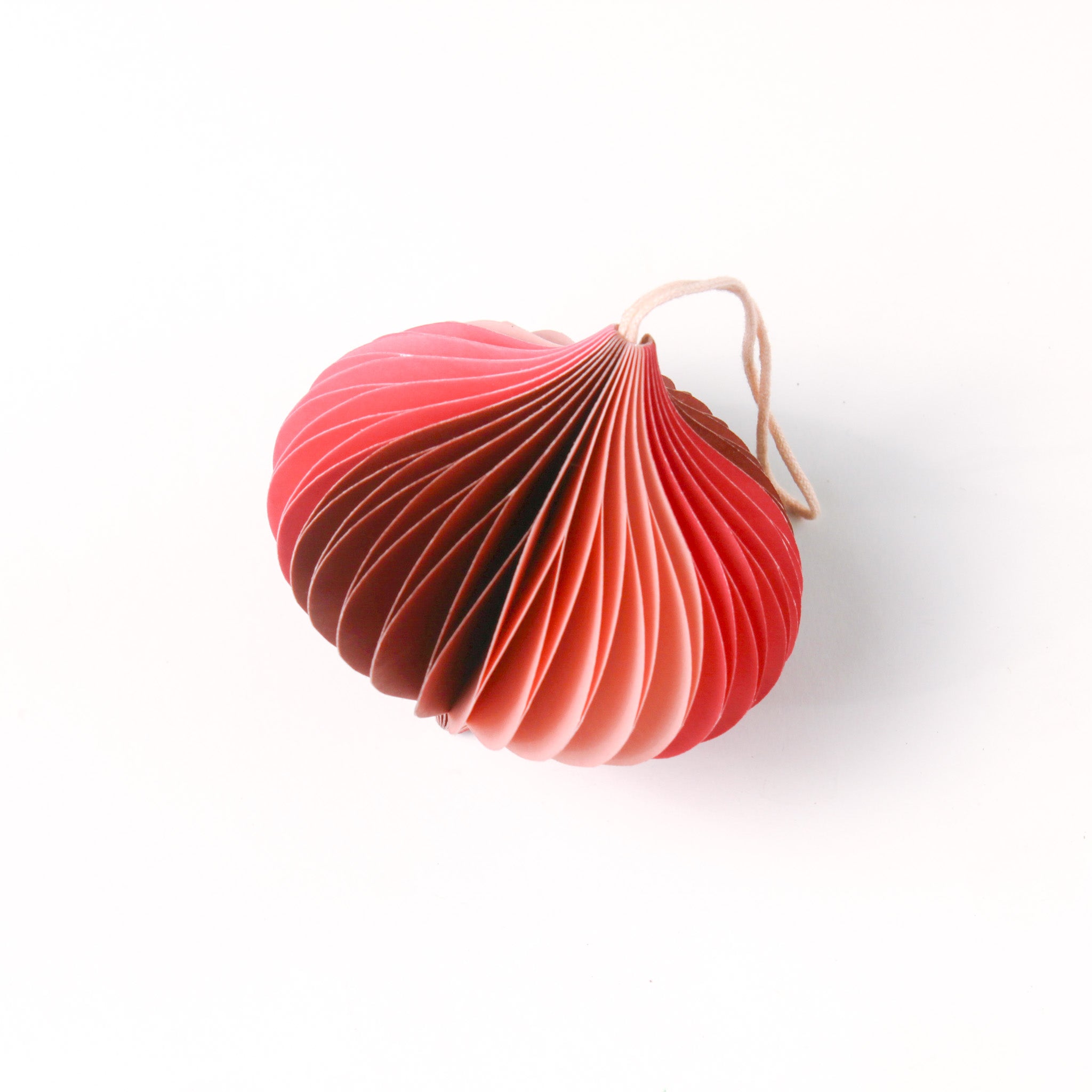 Close-up of pink folded paper Christmas ornaments in assorted bulb and teardrop shapes with hanging strings