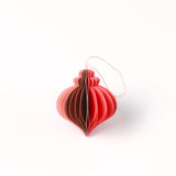 Close-up of pink folded paper Christmas ornaments in assorted bulb and teardrop shapes with hanging strings