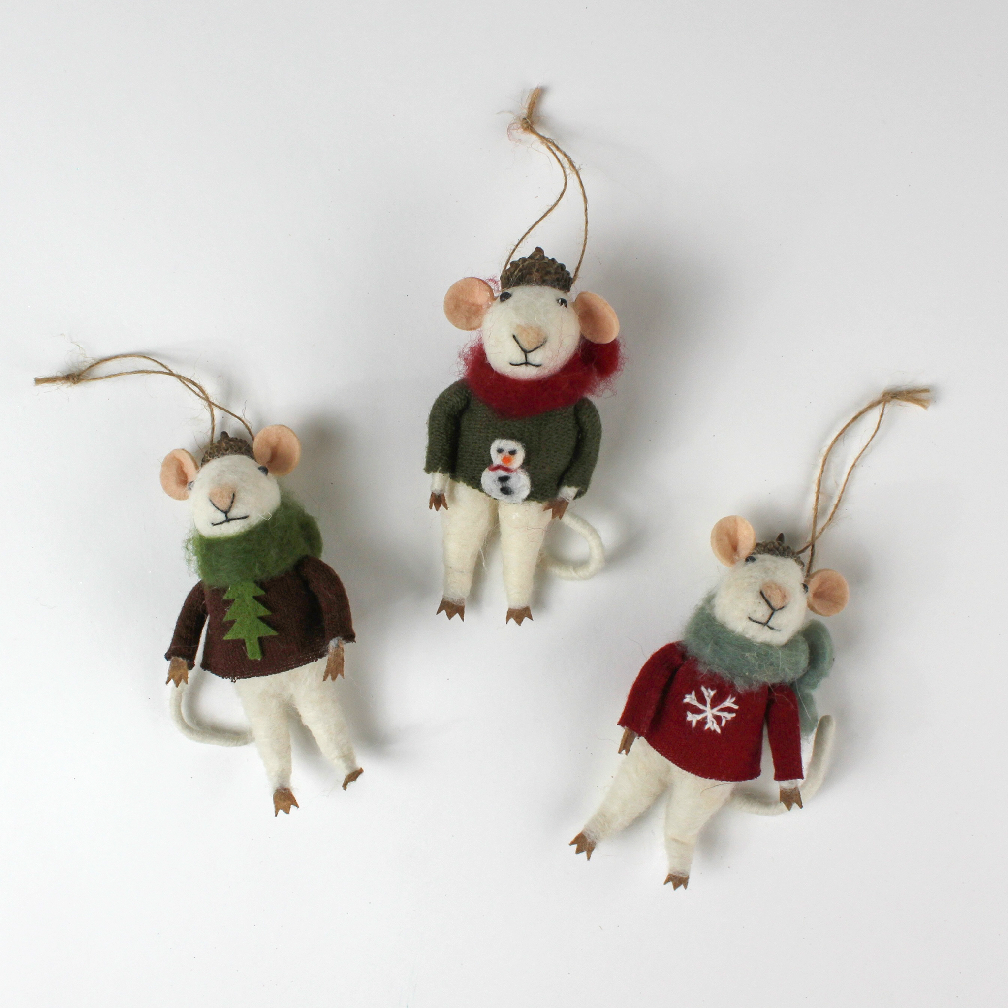 Three felt mouse ornaments wearing cozy sweaters with festive designs—a snowman, a tree, and a snowflake—each topped with a tiny acorn cap and ready to hang.
