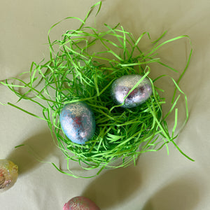 two foil egg decorations in nest