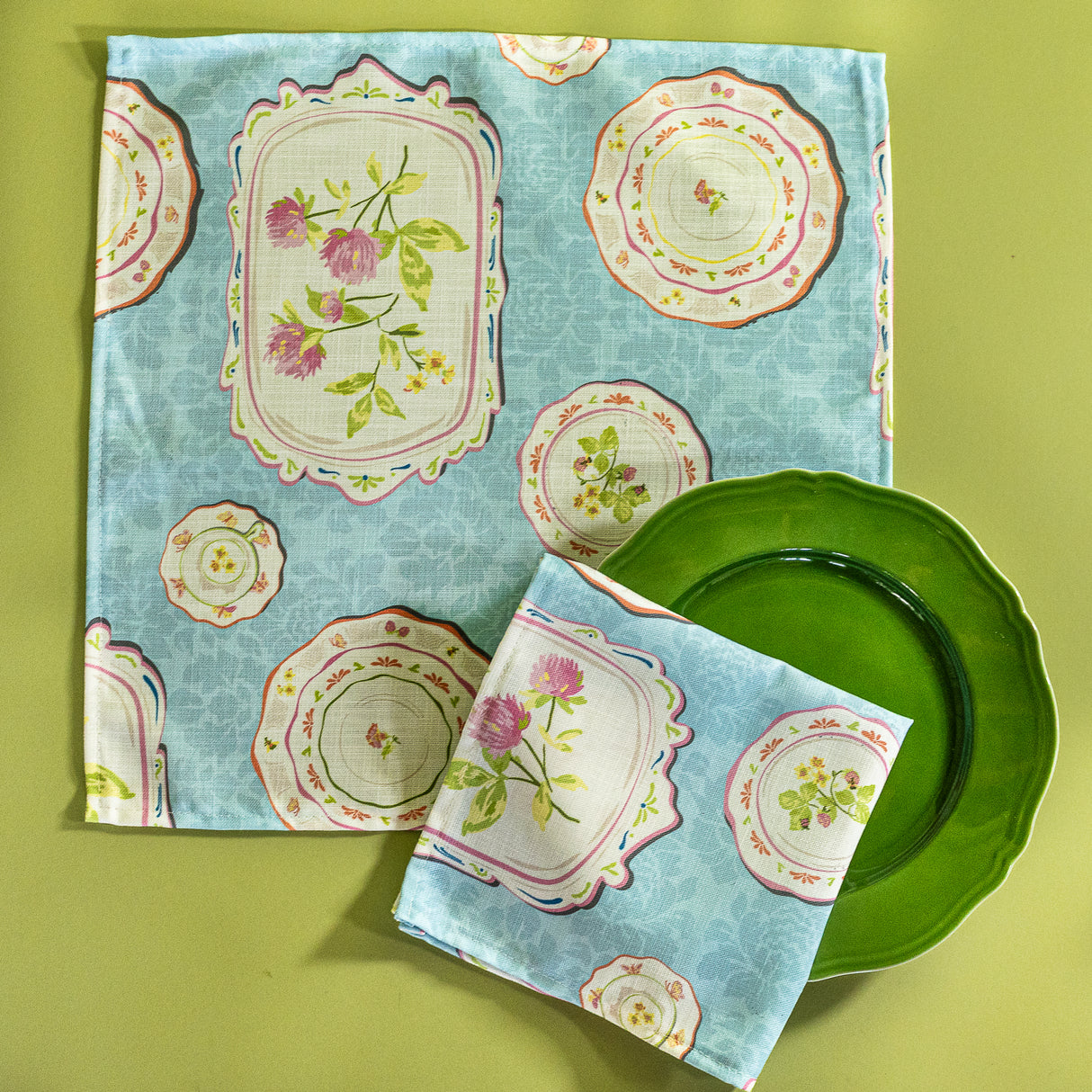 two fabric napkins in blue vintage plates fabric on a green plate. 