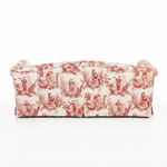 The back view of a sofa upholstered in a red and cream toile pattern, shown from the back against a plain white background.