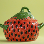 a large red vintage strawberry dish with a green handles and green detail on lid