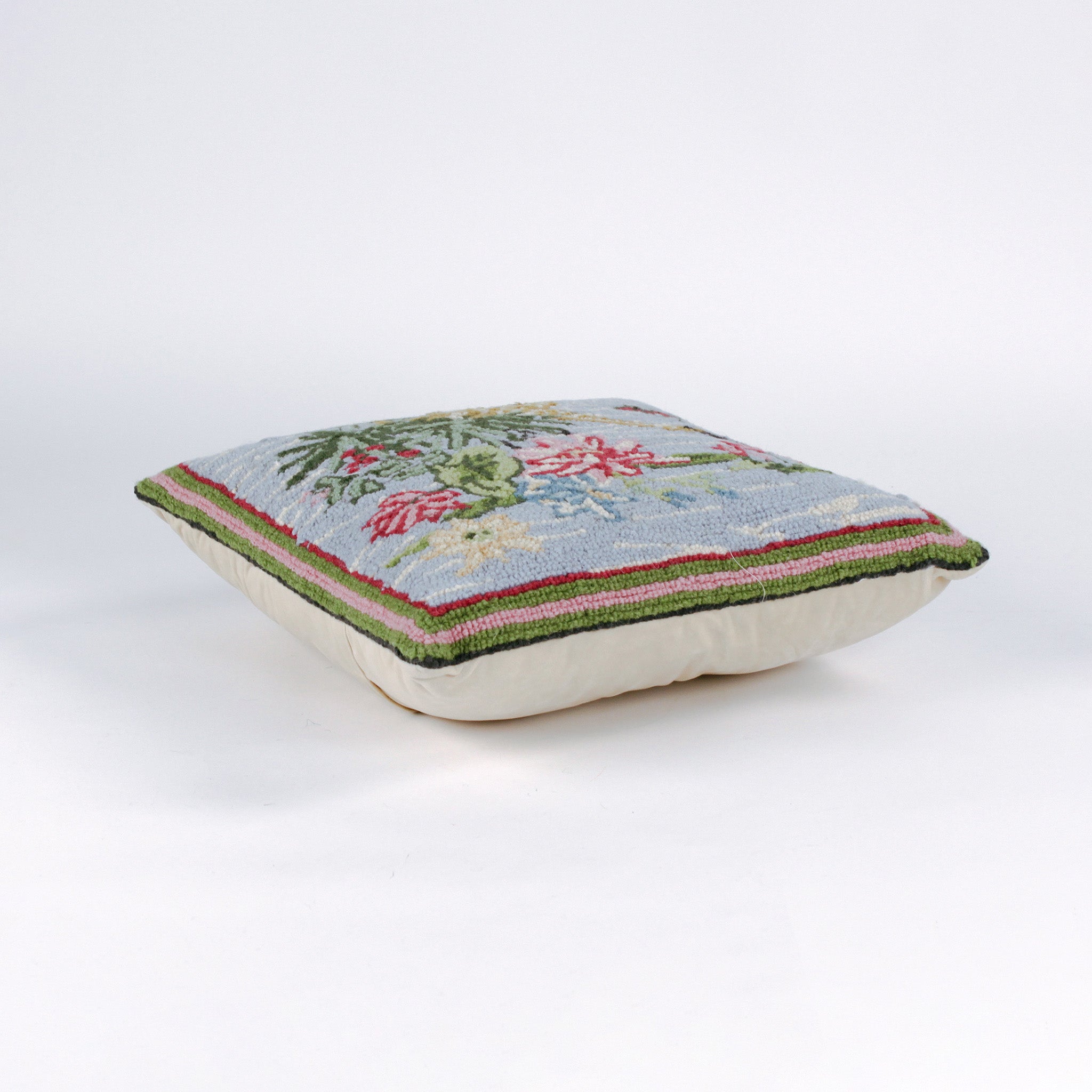Square decorative pillow with a hooked design featuring a yellow crane standing among green leaves and pink water lilies on a light blue background with a butterfly flying nearby.