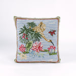 Square decorative pillow with a hooked design featuring a yellow crane standing among green leaves and pink water lilies on a light blue background with a butterfly flying nearby.