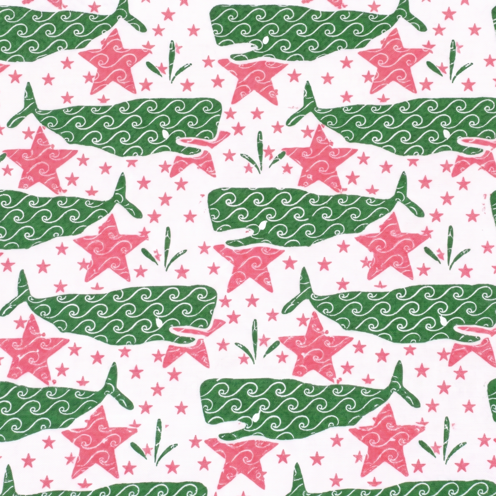 a white fabric with green whales and pink stars. 