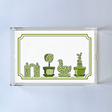 a rectangular acrylic tray with a white base and green topiary motifs on the bottom border. 