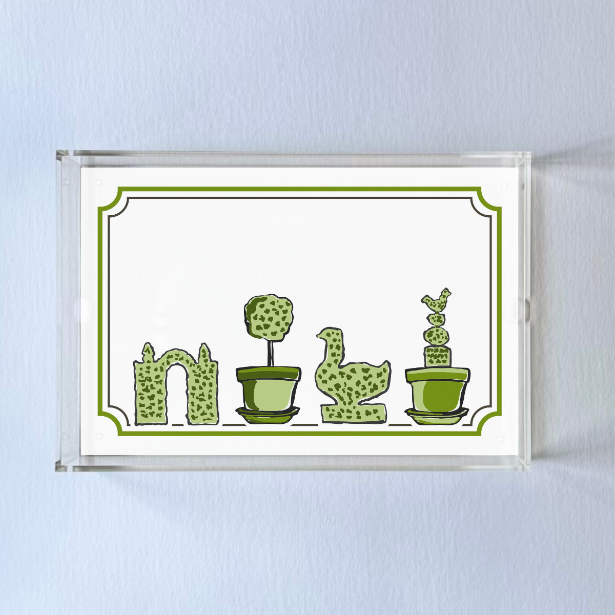 a rectangular acrylic tray with a white base and green topiary motifs on the bottom border. 