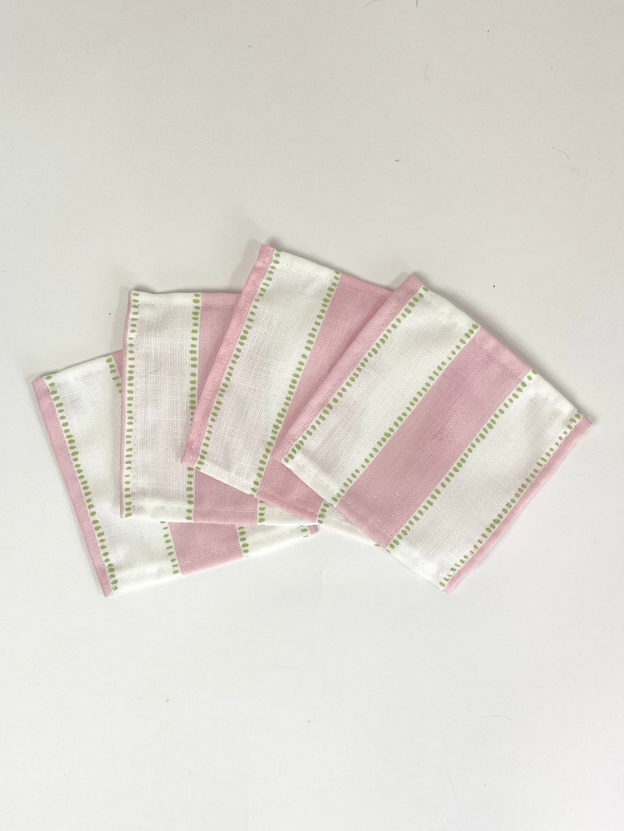 A set of four cotton white and pink stripe coasters in cabana boy print from madcap cottage