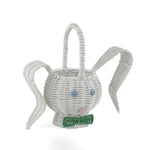 front side view of white wicker bunny basket with handle on white background