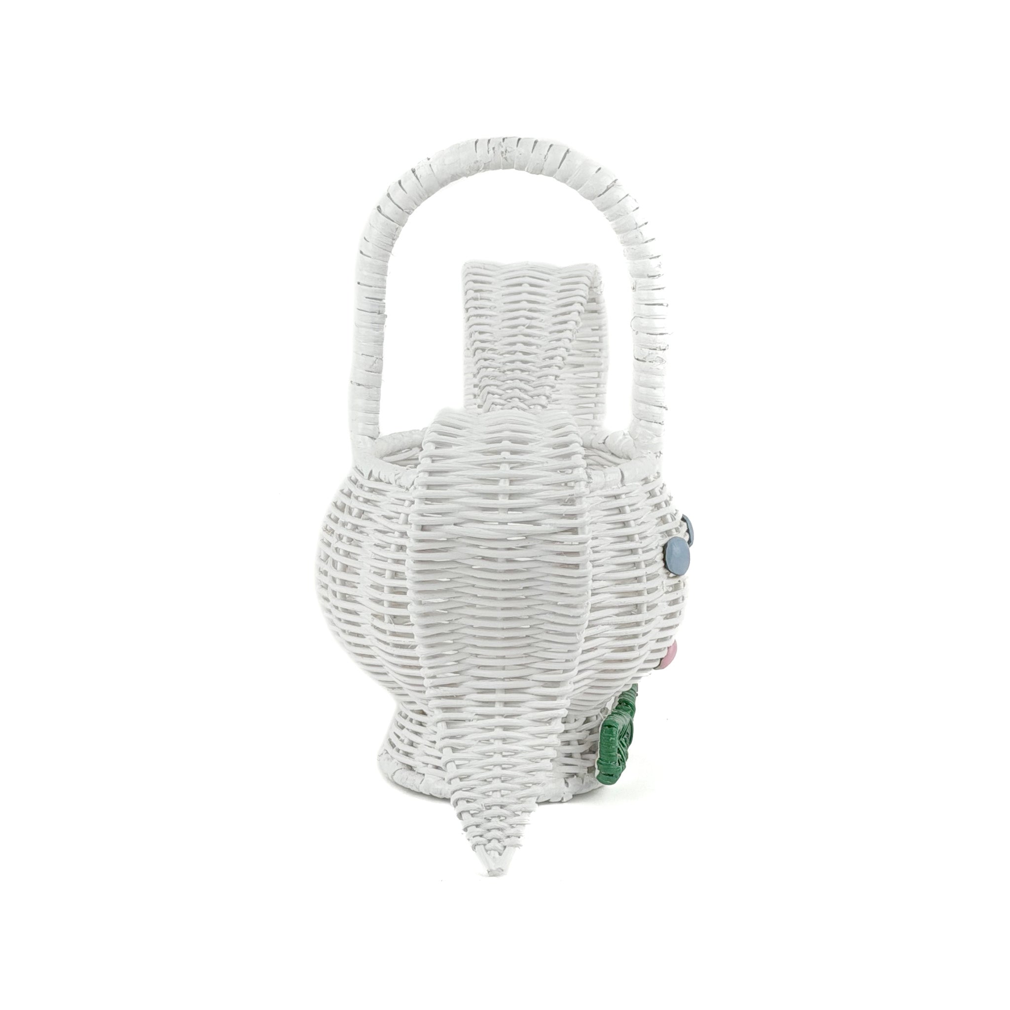 side view of white wicker bunny basket with handle on white background