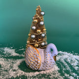 a Vintage White/Gold Ceramic Swan w/Gold Christmas Tree Centerpiece against a green background. 