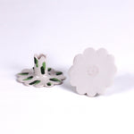 Set of two white ceramic scalloped taper candle holders with green brushstroke accents, shown from the top and side angles on a light background.