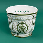 White ceramic cachepot with green trim and lattice design featuring a green floral medallion on the front