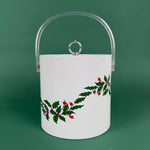 White Christmas ice bucket with holly and red berry design and a clear handle on a green background