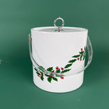 White Christmas ice bucket with holly and red berry design and a clear handle on a green background