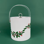 White Christmas ice bucket with holly and red berry design and a clear handle on a green background