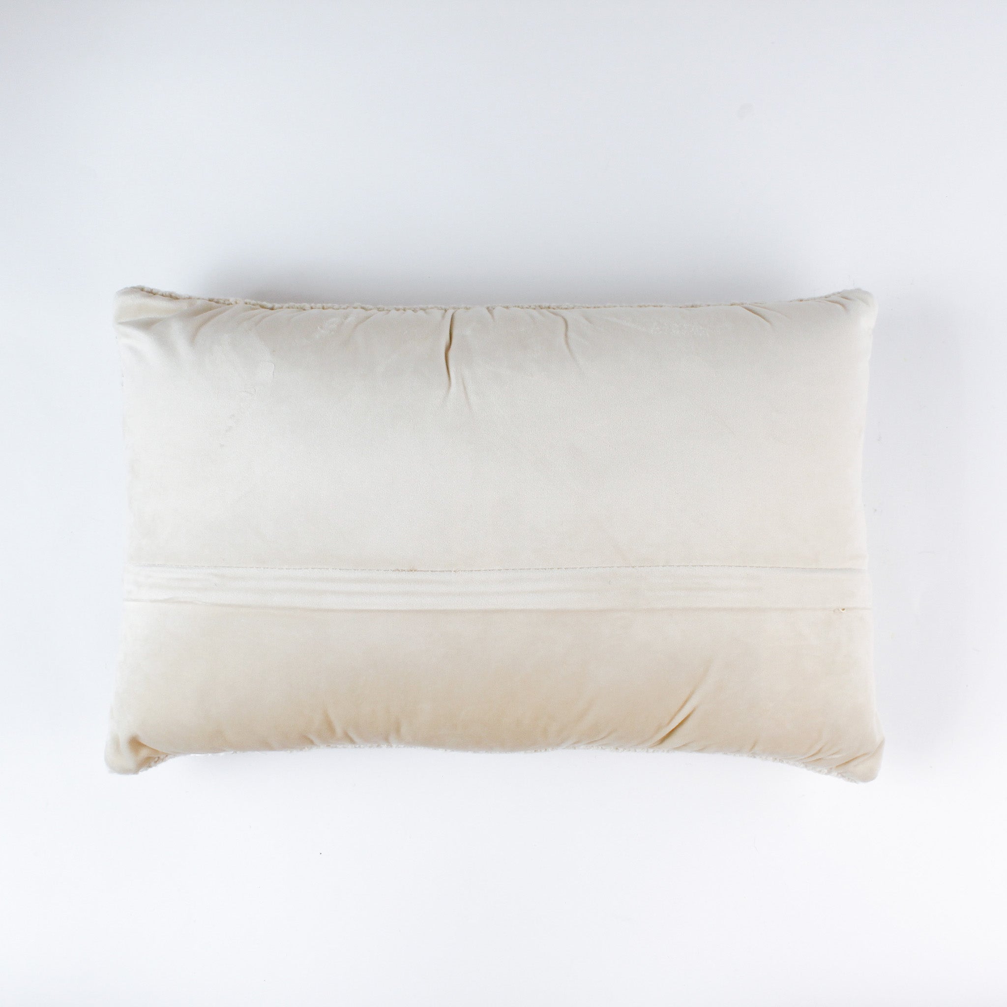 back of a Rectangular white pillow with a hooked wool design featuring colorful skis, poles, boots, and scarves hanging on a wooden rack, evoking a cozy winter ski lodge feel.