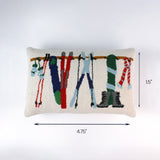 Rectangular pillow with colorful ski gear hanging from a rack shown with a 4.75 inch length and 1.5 inch height indicator.