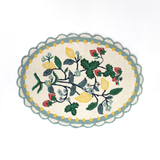 An small oval scalloped rug with strawberry and floral motifs