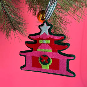 pink felt chinoiserie christmas ornaments in the shape of pagodas against a red background 