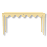 A custom yellow console table with scalloped edges