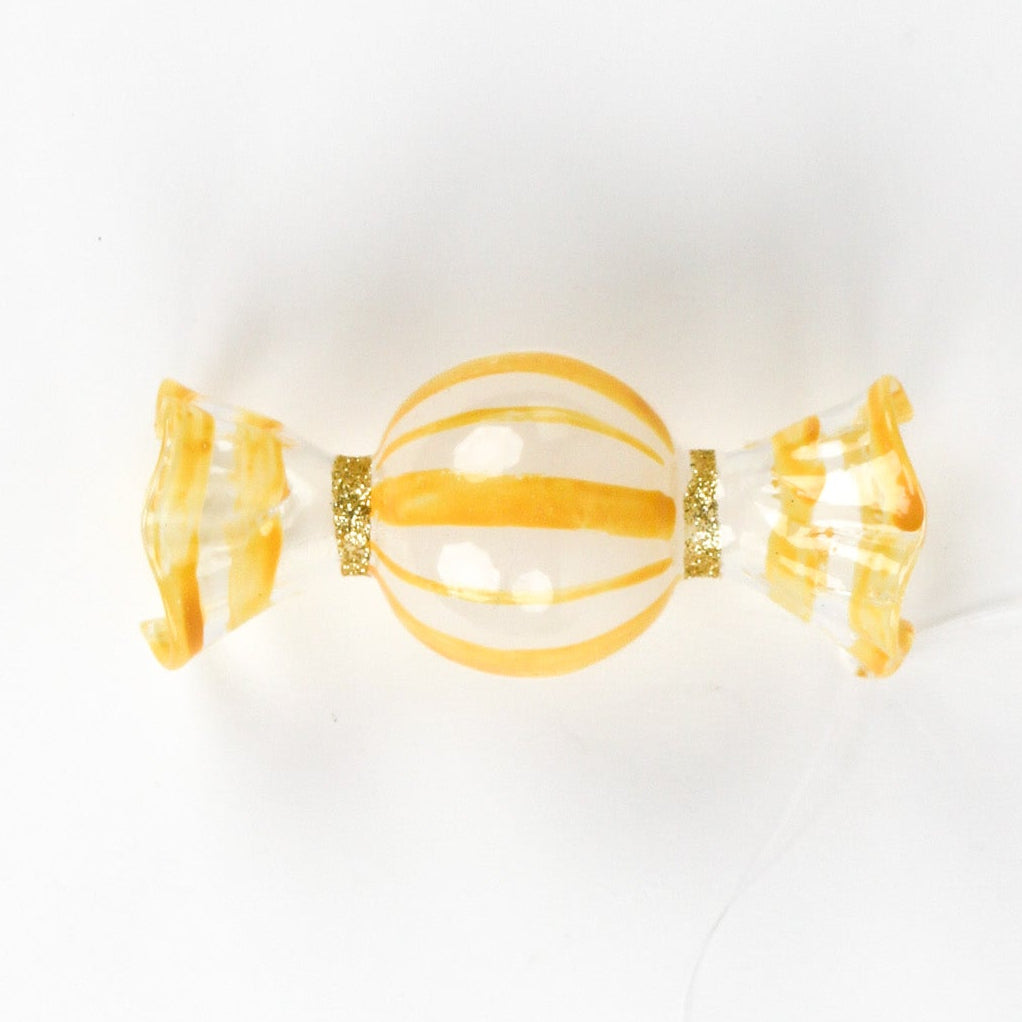 yellow glass candy christmas ornament on a white background