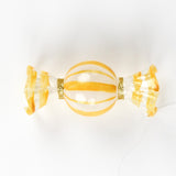 yellow glass candy christmas ornament on a white background