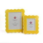 Two yellow scalloped photo frames on a white background