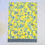 a yellow chinoiserie tea towel with blue cherry blossom motifs.