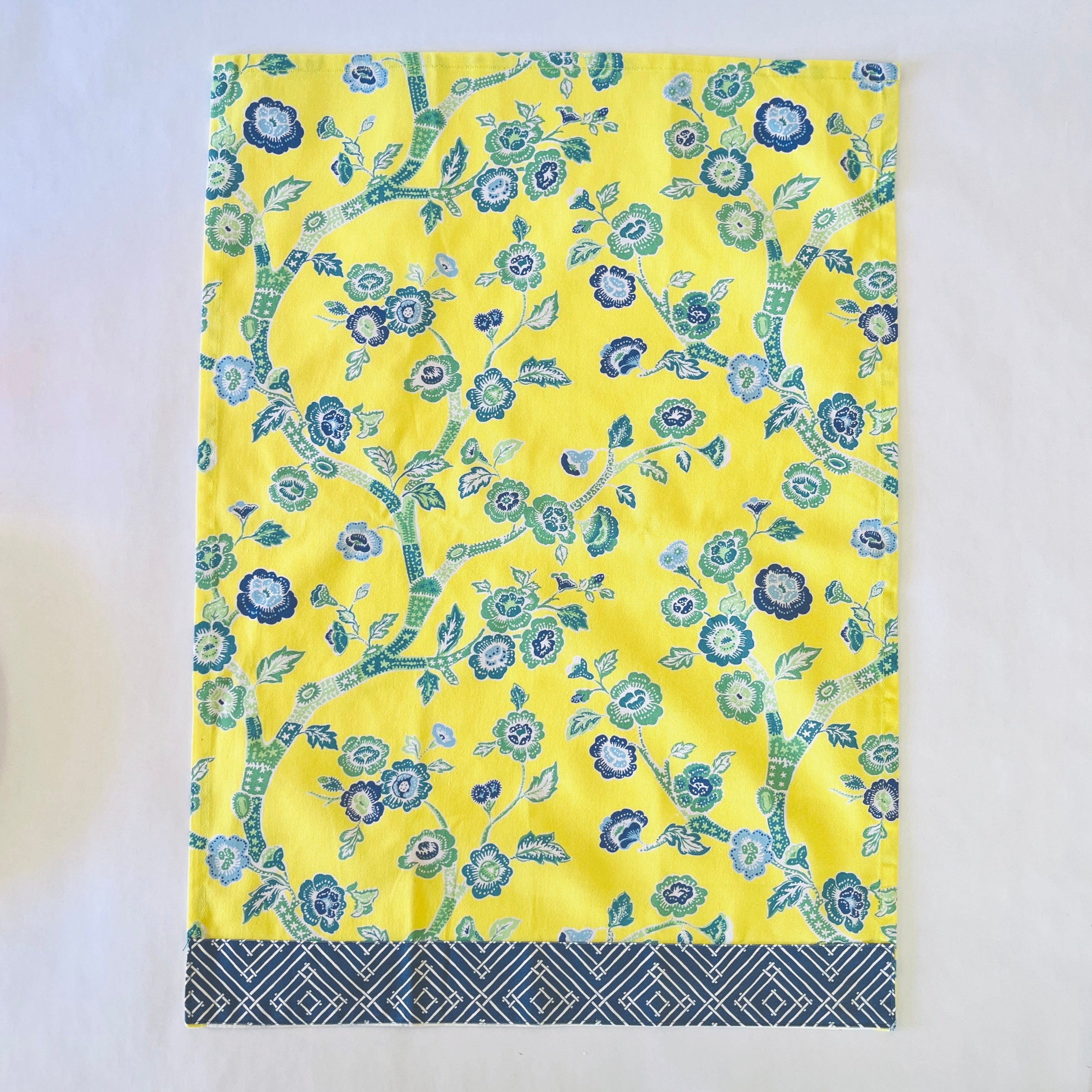 a yellow chinoiserie tea towel with blue cherry blossom motifs.