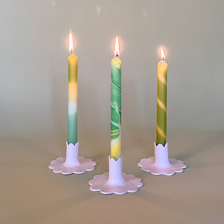 yellow and green assorted taper candles in white scalloped candle holders