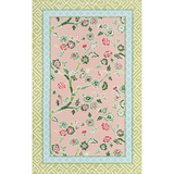 Pink and green rug with pink and blue floral centre motif and green geometric border