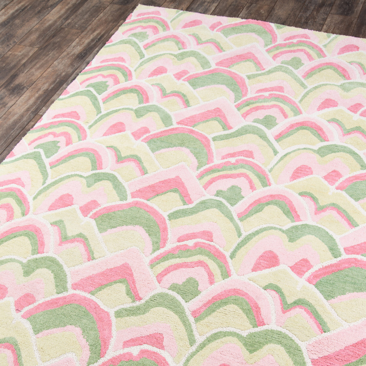 Corner details of a pink and green rug in an abstract pattern