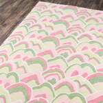 Corner details of a pink and green rug in an abstract pattern