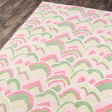 Corner details of a pink and green rug in an abstract pattern