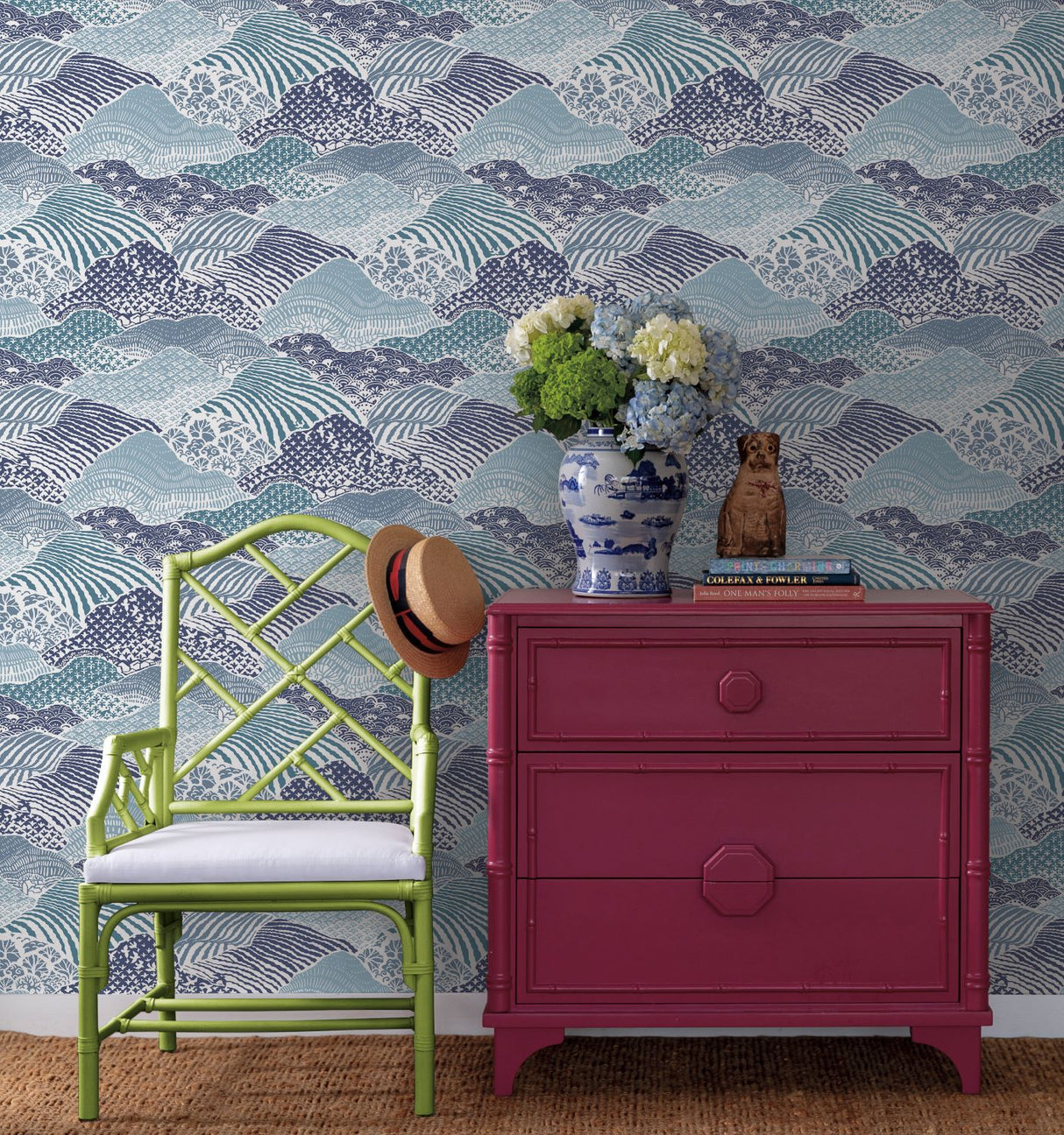 A green chair and red chest against a background of blue removable wallpaper
