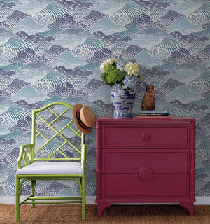 A green chair and red chest against a background of blue removable wallpaper