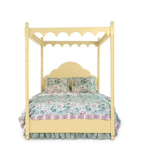 a four poster yellow canopy bed with floral bedding 
