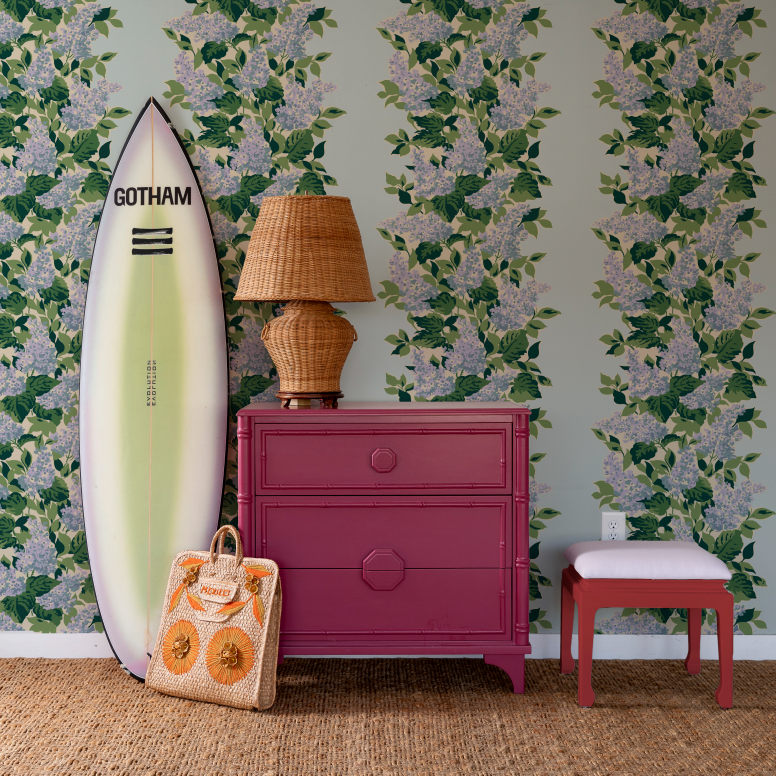 surfbooard and pink chest against a blue and pink wallpaper featuring a leafy hydrangea motif.